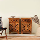 Pair of mango wood night stands with hand carved floral and geometric detailing, warm teak finish; elegant hand carved furniture, 45 × 35 × 65 cm.