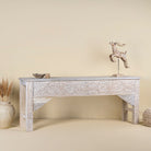 Side angle image of a hand-carved whitewashed reclaimed wood console table with floral details; vintage home decor with rustic and bohemian charm, 196 × 44 × 80 cm.