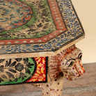 Close up image of a Aaroh hand-painted reclaimed wood coffee table with sculpted tiger heads and colourful ornamental design 80cm
