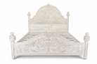 Wite background image of a hand carved white washed Mango wood bed frame in mediterrane style.