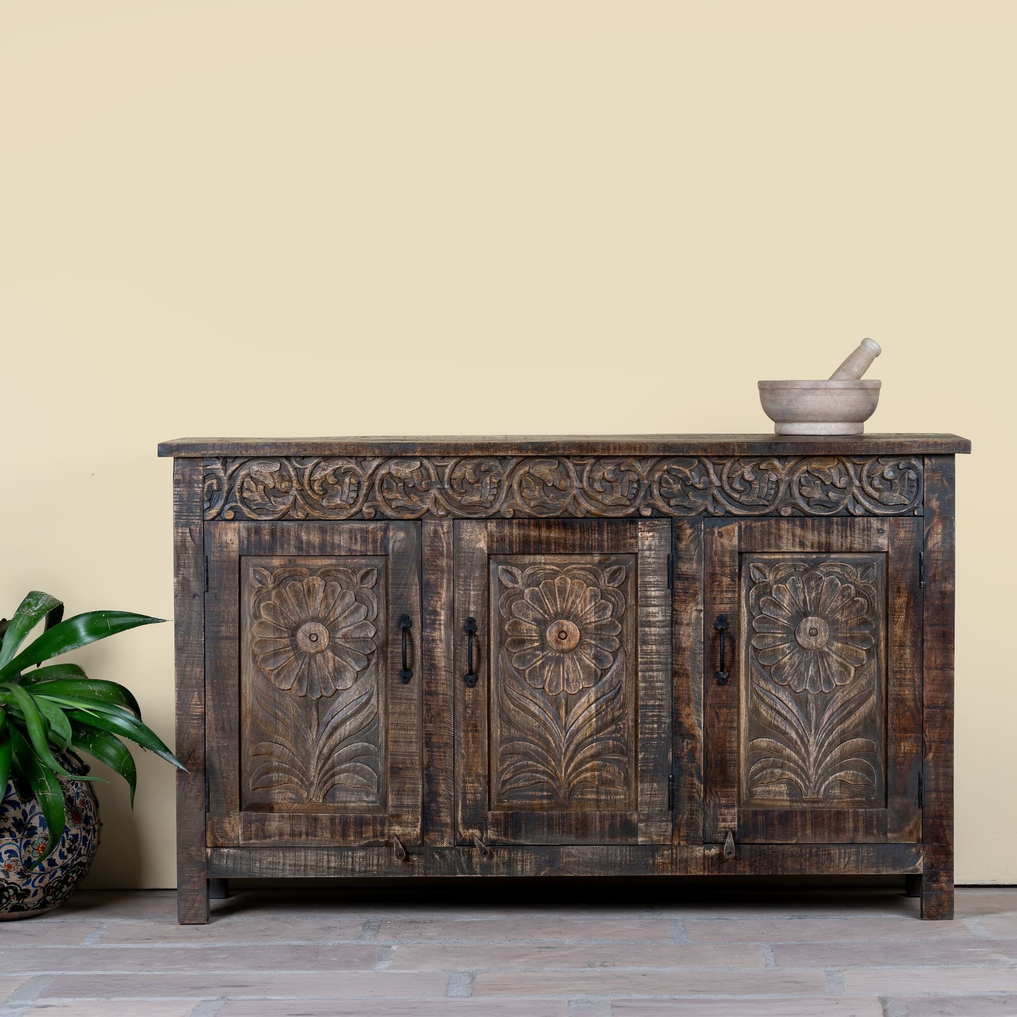 Image of a dark brown hand carved mango wood sideboard with floral design and ample storage.