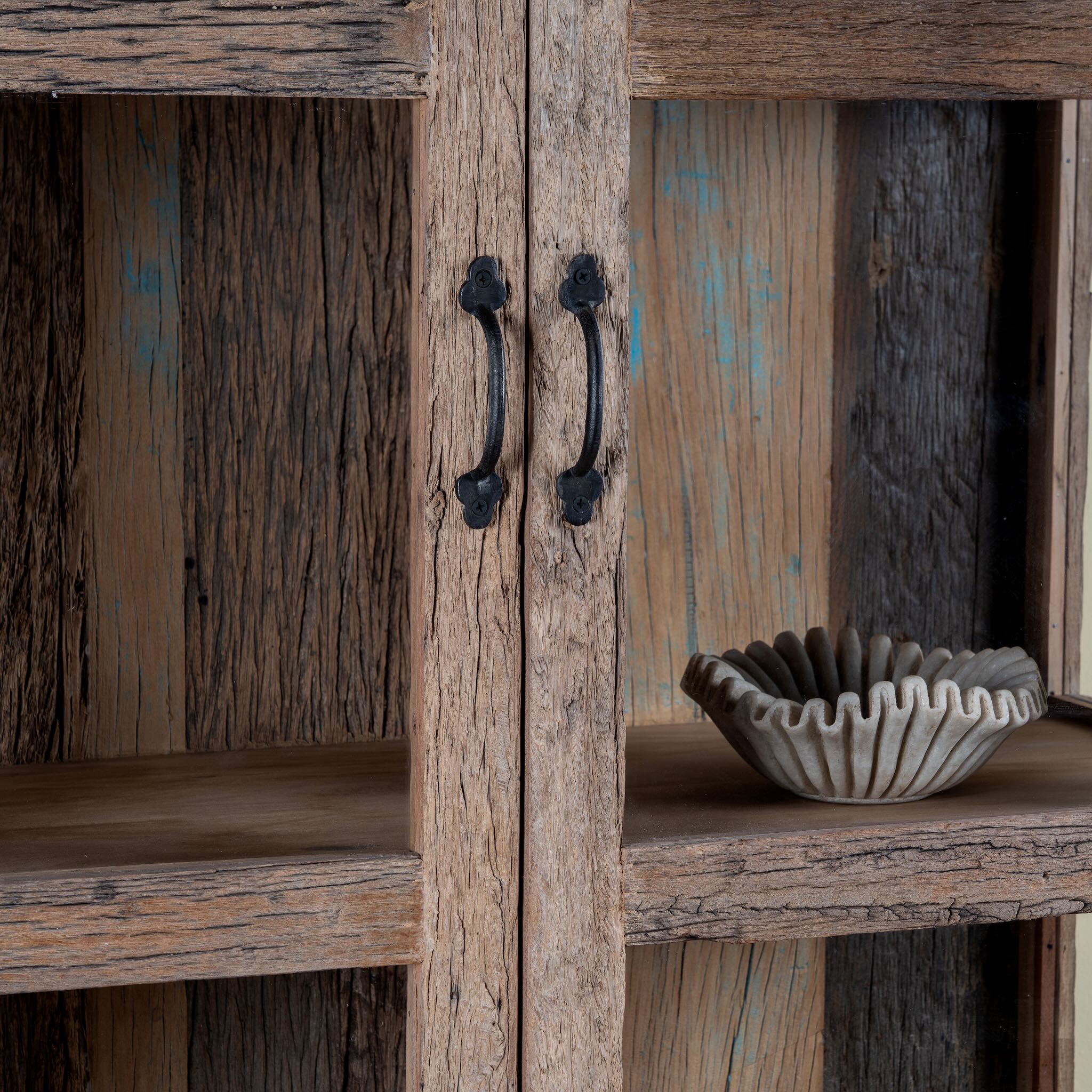 Close up image of a driftwood display cabinet with 2 glass doors and 4 shelfs in rustic design.