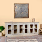 Side angle image of a sandblasted reclaimed wood sideboard in Ibiza style with four glass-panelled doors, vintage Mediterranean furniture, 263×45×100 cm.