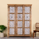 Image of a hand carved wardrobe with floral design made of mango wood in vintage style.