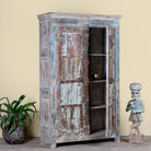 Side angle image with open doors of a antique Indian Door Wardrobe with generated colours and iron fittings in vintage style made of teak wood.