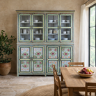 Lifestyle image of a large hand painted, 2 parts, Mango wood display cabinet wit 8 doors and ample inside storage in vintage design.