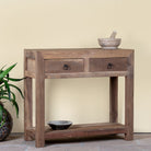 Side angle image of a reclaimed wood console table with 2 drawers and one shelf in driftwood style.