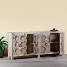 Side angle image with open doors of an Indian antique door sideboard with ample storage and original iron settings.