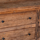 Close up image of a chest of 6 drawers in Japandi style made of reclaimed dark wood.