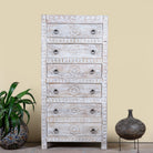 Inmage of a hand carved white washed mango wood chest of 6 drawers in mediterranean design with iron 
handles.
