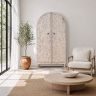 Lifestyle inspiration of an arched wooden wardrobe made of mango wood with hand-carved floral details; hand carved wooden furniture in Ibiza style, 190 × 100 × 40 cm.