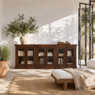Lifestyle image of a reclaimed teak furniture sideboard with glass doors, rustic living room furniture with boho style, 257 × 46 × 100 cm.