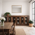 Lifestyle image of a reclaimed teak furniture sideboard with glass doors, rustic living room furniture with boho style, 257 × 46 × 100 cm.