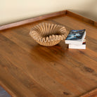 Close up image of a rustic square mango wood coffee table with raised edge, vintage-style entryway or living room furniture, 120×120×40 cm.