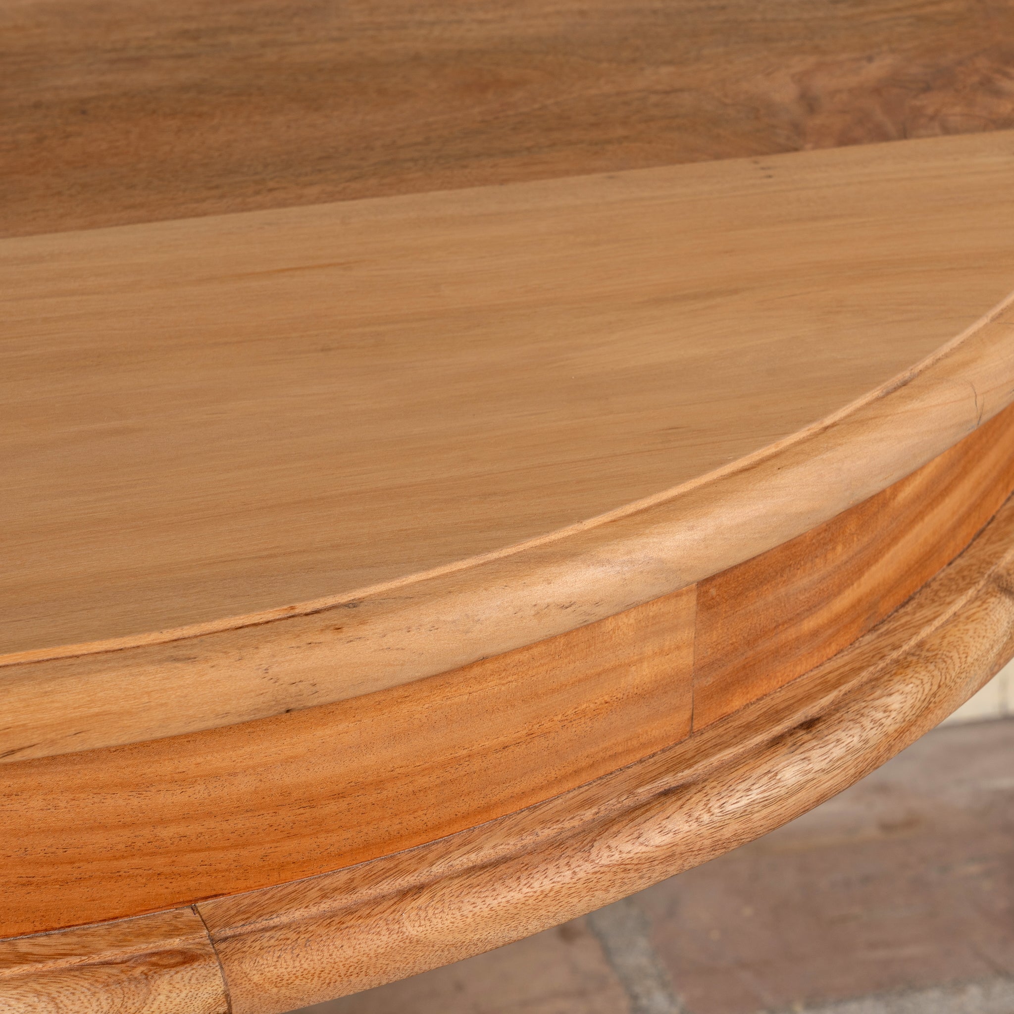 Close up image of a round solid wood dining table made from reclaimed teak with carved pedestal base; rustic reclaimed teak wood dining table, 100 cm diameter × 78 cm height.