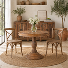 Lifestyle image of a round solid wood dining table made from reclaimed teak with carved pedestal base; rustic reclaimed teak wood dining table, 100 cm diameter × 78 cm height.