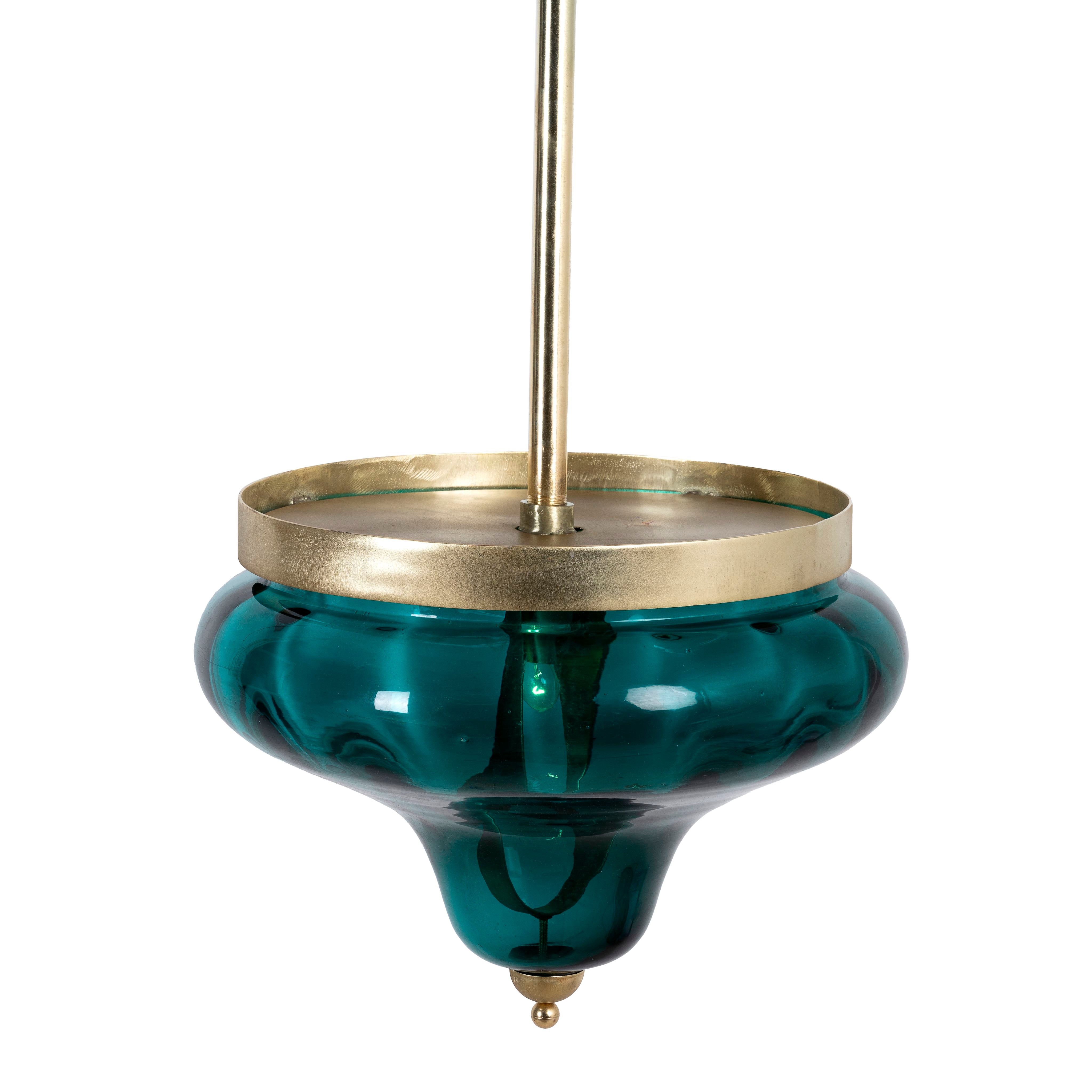 A large green glass pendant light with a brass plated frame and a metal rod attachment.
