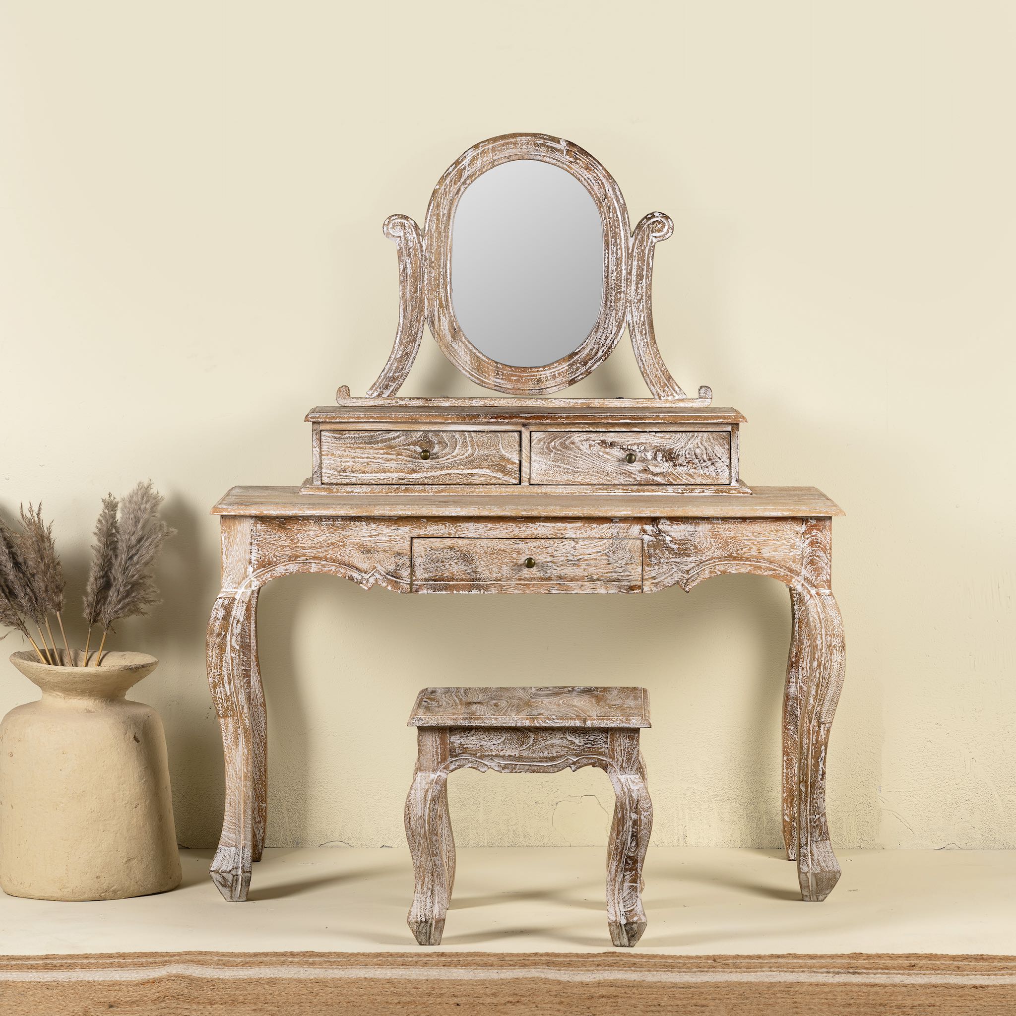 A handcrafted mango wood cosmetic table with a curved mirror and matching stool, showcasing a vintage style with a beige finish.