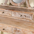 Close up image of a handcrafted mango wood cosmetic table with a curved mirror and matching stool, showcasing a vintage style with a beige finish.