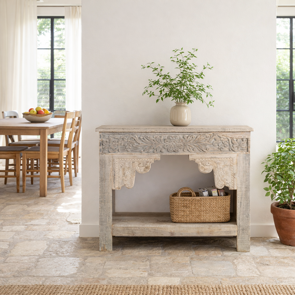 Lifestyle imagination of a handcrafted reclaimed teak wood console table with sandblasted finish, carved floral detailing, vintage corbels, and lower shelf; perfect for styling with vintage home accessories, 133 × 62 × 90 cm.