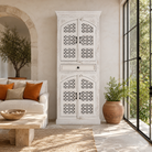 Lifestyle image of a Aesha white washed mango wood cabinet with Oriental hand carved doors 180cm