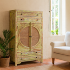 Green-washed mango wood cabinet with floral carvings, rattan door inserts, versatile living room furniture, 80 × 148 × 40 cm.