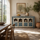 Lifestyle image of a hand carved showcase made of natural mango wood in white washed with blue floral accents and half glass doors in vintage design.