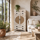 Lifestyle image of a Ahalya handcrafted solid mango wood cabinet with hand-carved floral doors, natural rattan inserts, four drawers, two storage compartments, and Mediterranean-inspired design, 148cm.