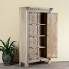 Side angle image with open door of a reclaimed teak wood cabinet Ahara with Mediterranean design, featuring hand-carved antique Indian doors and metal accents. A unique piece of old door furniture ideal for stylish, character-rich living room storage.