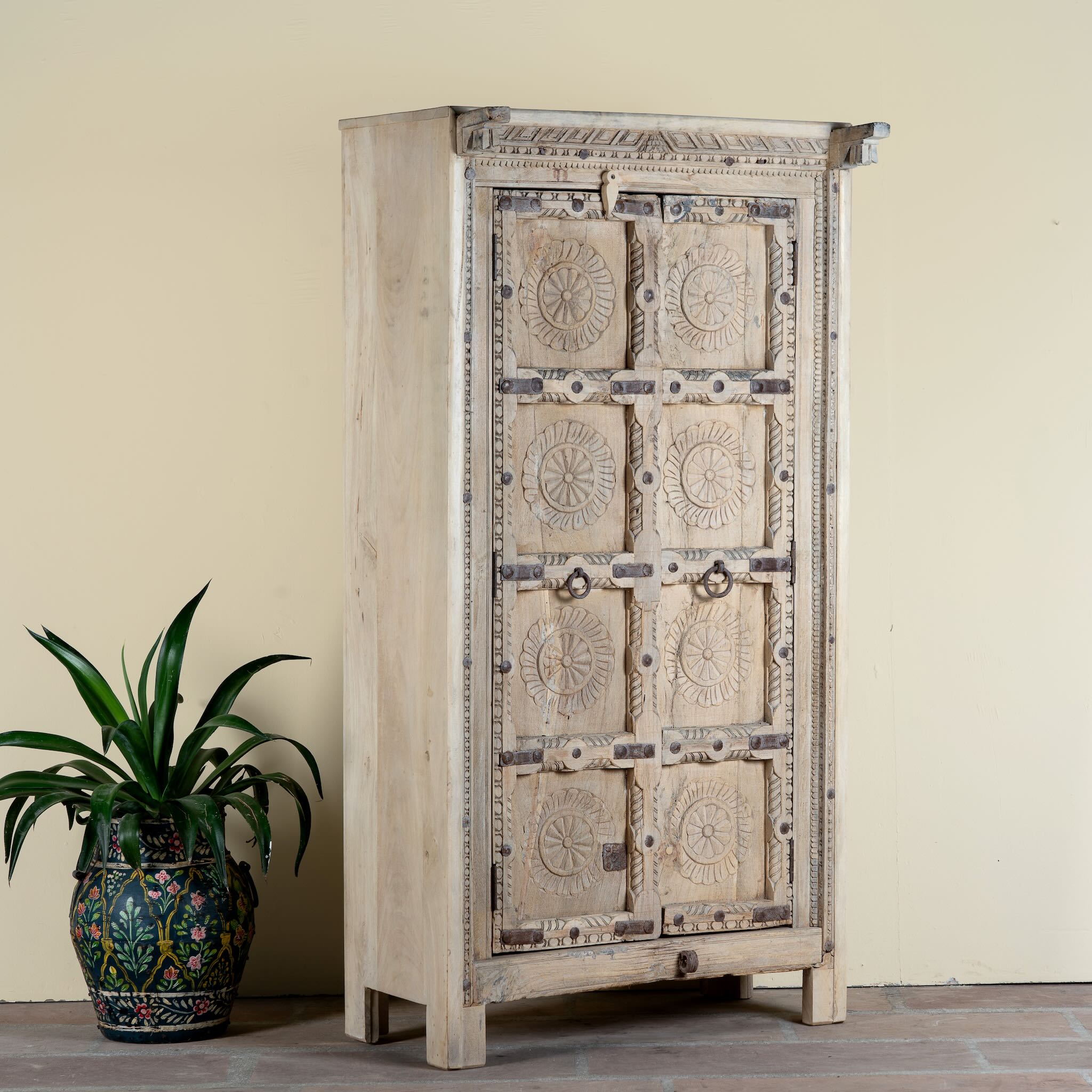 Side angle image of a reclaimed teak wood cabinet Ahara with Mediterranean design, featuring hand-carved antique Indian doors and metal accents. A unique piece of old door furniture ideal for stylish, character-rich living room storage.