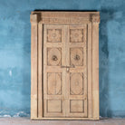 Antique Indian door Akshara in reclaimed teak with brass locks, hand-carved details, extended frame, unique furniture and vintage wall panels, 148 × 30 × 225 cm.