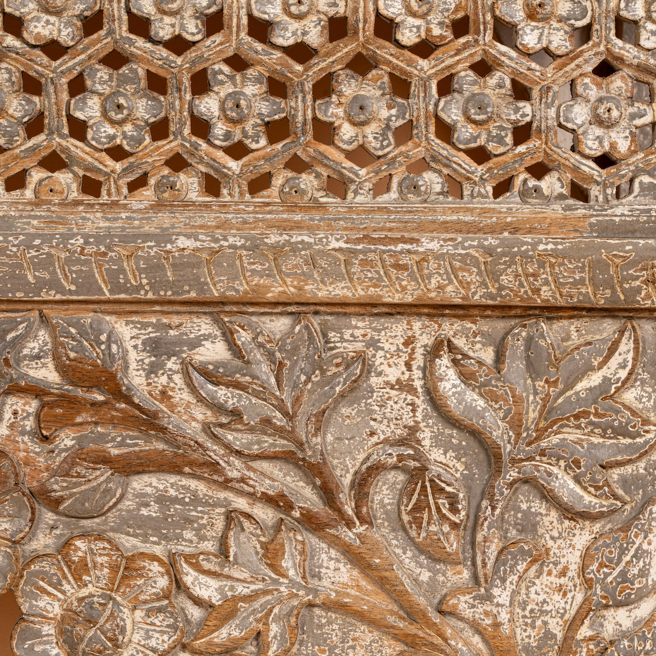 Close up image of a vintage console table in mango wood with hand-carved floral and geometric patterns and arched detailing; carved console table, 150 × 90 × 40 cm.