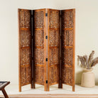 Foldable room partition made from mango wood, featuring four panels with intricate hand-carved floral and lattice designs, finished in a warm natural tone and connected by black metal hinges for flexible positioning.
