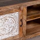 Close up image of a wood carved sideboard Alka, Indian furniture made from mango wood with floral carvings, whitewashed finish, 150 × 40 × 60 cm.