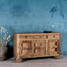 Side view image of a rustic design sideboard made from reclaimed wood with panelled doors, drawers, and iron accents; 150 × 40 × 90 cm.