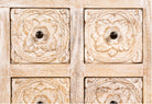 Close up image of a whitewashed mango wood lowboard with hand-carved floral details, eight drawers and two compartments; ideal as a wooden lowboard or carved wood console table, 180 × 60 × 40 cm.