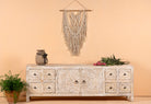 Whitewashed mango wood low board with hand-carved floral details, eight drawers and two compartments; ideal as a wooden low board or carved wood console table, 180 × 60 × 40 cm.