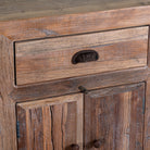 Close up image of a reclaimed wood sideboard Amira in a rustic minimalist design, featuring three drawers and six doors with iron handles. A sustainable piece of living room furniture with natural textures and timeless appeal.