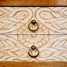 Close up image of a white washed mango wood console table with floral hand-carved drawers and lower shoe shelf; rustic mango wood furniture, 90 × 40 × 75 cm.