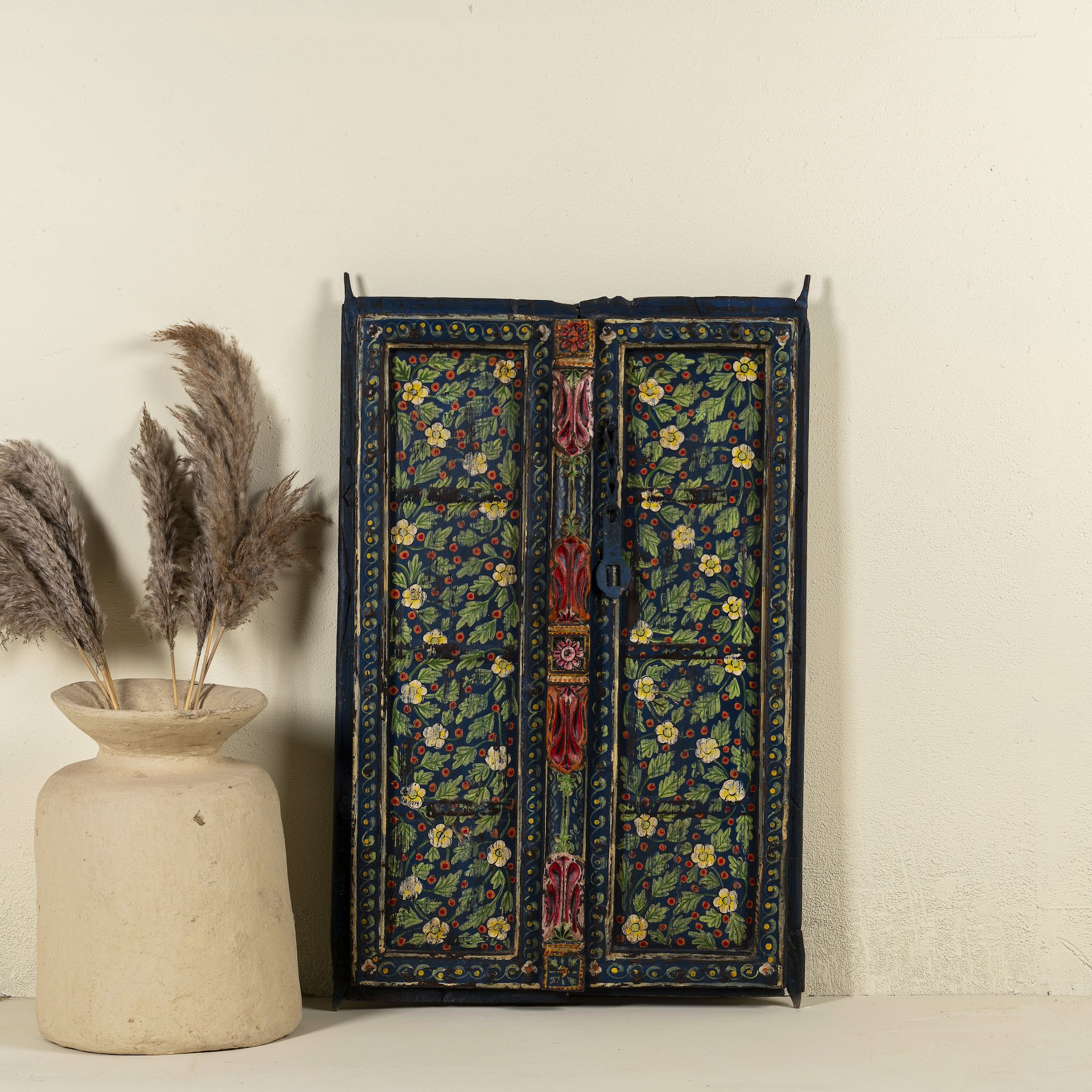 Decorative wall panel made from an old teak wood window frame, hand-painted with intricate floral patterns in vibrant colours including green, red, yellow, and blue, showcasing traditional Indian craftsmanship and vintage charm.
