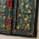 Side angle image of a decorative wall panel made from an old teak wood window frame, hand-painted with intricate floral patterns in vibrant colours including green, red, yellow, and blue, showcasing traditional Indian craftsmanship and vintage charm.
