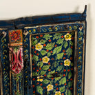 Close up image of a vintage hand-painted wall panel made from reclaimed Indian teak wood with floral blue motifs – Amol model by Om Home & Garden