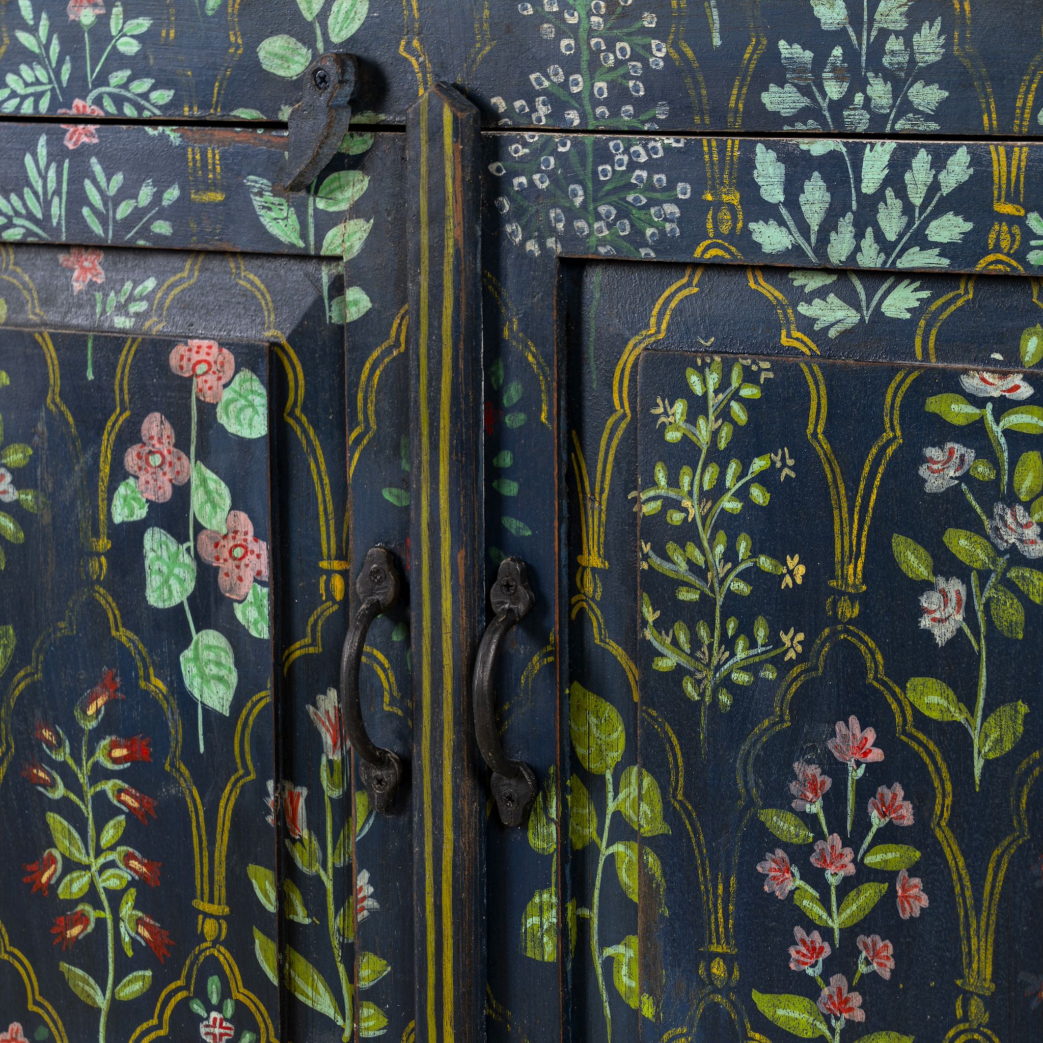 Close up image of a hand painted cupboard made from recycled wood with floral motifs, two drawers and two doors, 90 × 90 × 40 cm.