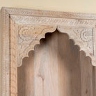 Close up image of a hand carved entryway shelf with storage and two drawers made of mango wood, hand carved.