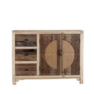 White background image of a reclaimed wood sideboard Amruta with three drawers and rattan-inlay cabinet doors in a circular design. A piece of sustainable furniture blending rustic wood textures and handcrafted detail.