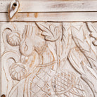 Close up image of a hand-carved mango wood sideboard with peacock and foliage motifs, whitewashed finish; perfect for Indian home decor, 150 × 95 × 40 cm.