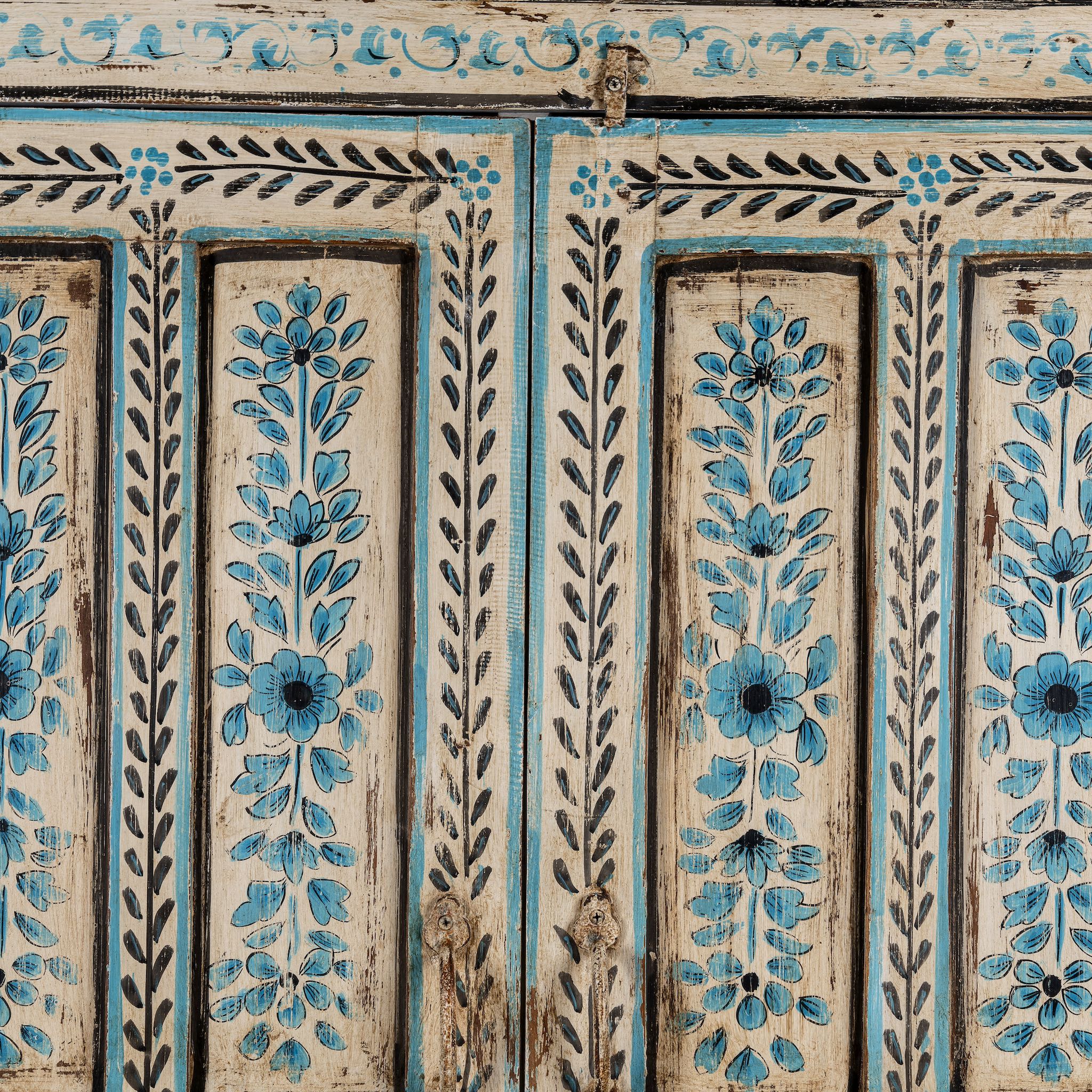 Close up image of a hand painted wooden furniture cabinet with floral motifs, reclaimed teak artisanal furniture in Mediterranean style, 95 × 40 × 152 cm.