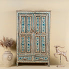 Front view image of a hand painted wooden furniture cabinet with floral motifs, reclaimed teak artisanal furniture in Mediterranean style, 95 × 40 × 152 cm.