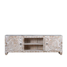 White background image of a white washed mango wood lowboard with carved floral doors and open shelving, 180 × 40 × 60 cm.