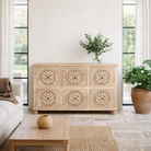 Lifestyle image of a hand-carved mango wood sideboard with Mediterranean drawer motifs and whitewashed finish; ideal carved sideboard or entryway table vintage, 150 × 90 × 40 cm.